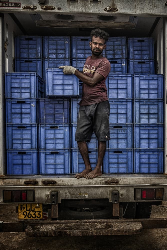 Man Loading Blue Crates by Pavol Stranak — canvas wall art