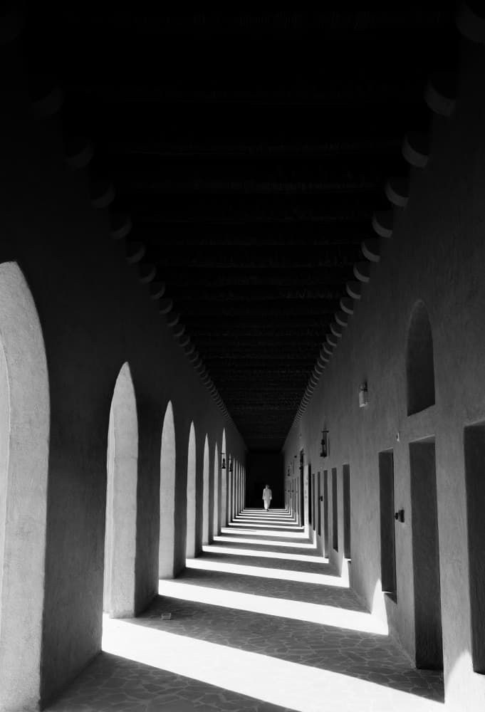 Lone Figure Arched Hallway by Karim Al Thahaby — canvas wall art