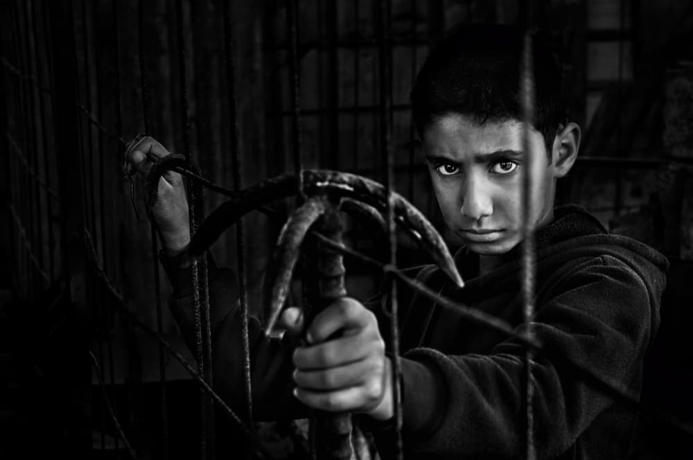 Intense Boy Behind Bars by Saeed Dhahi — canvas wall art