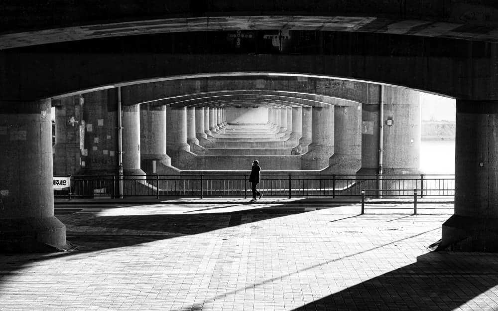Solitary Figure Under Bridge by Bong Goo Kang — canvas wall art