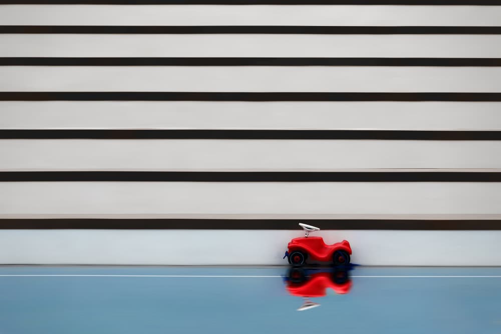 Red Toy Car Reflection by Hans-Wolfgang Hawerkamp — canvas wall art