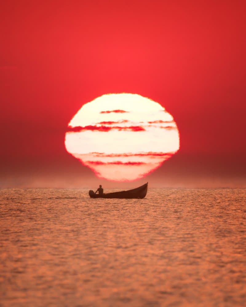 Red Sun Solitary Boat by Alexandru Handrache — canvas wall art