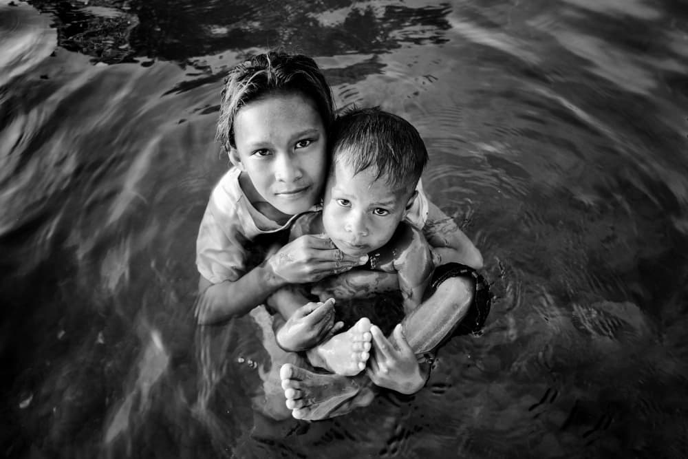 Young Siblings In Water by Kieron Long — canvas wall art