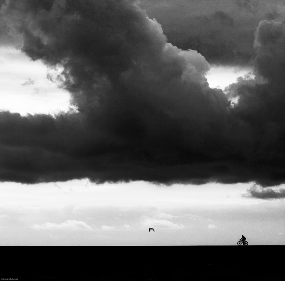 Cyclist Under Dark Clouds by Luciano Caturegli — canvas wall art