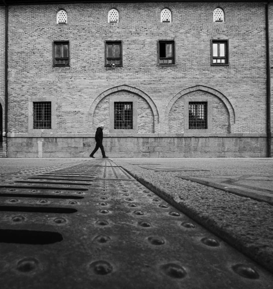 Lone Figure Brick Building by Doruk Uysal — canvas wall art