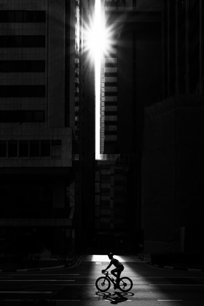Silhouetted Cyclist Sunbeam by Simon — canvas wall art