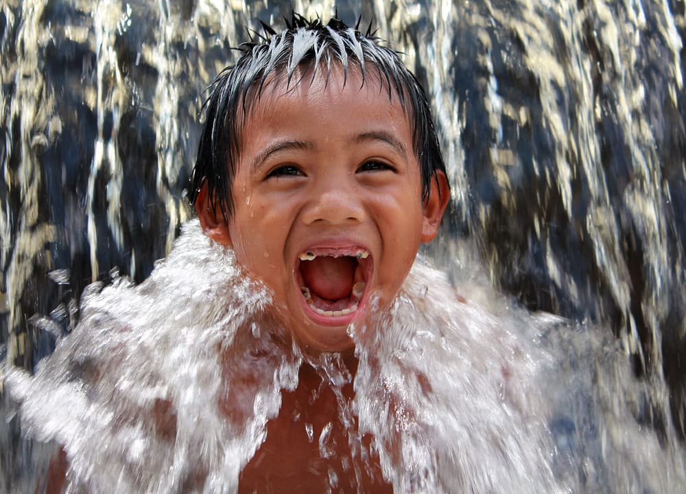 Joyful Child Splashing by Abdul Gapur Dayak — canvas wall art