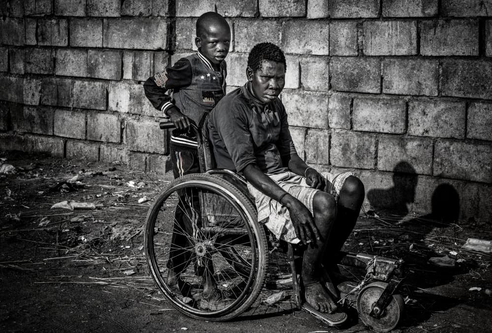 Boy Pushing Wheelchair by Joxe Inazio Kuesta Garmendia — canvas wall art