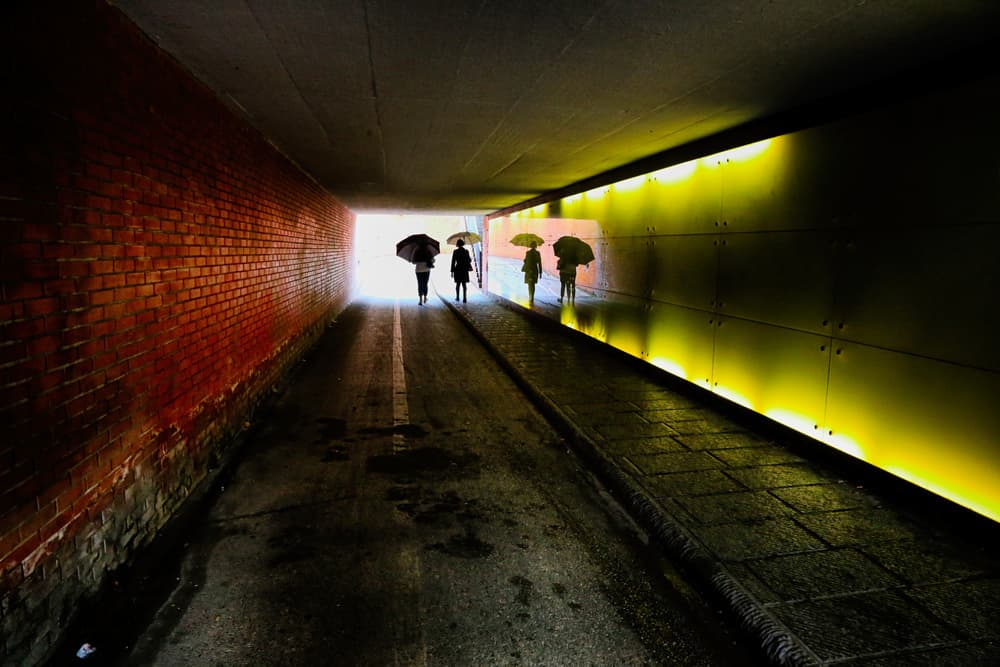 Umbrellas Through Tunnel Light by Luciano Caturegli — canvas wall art