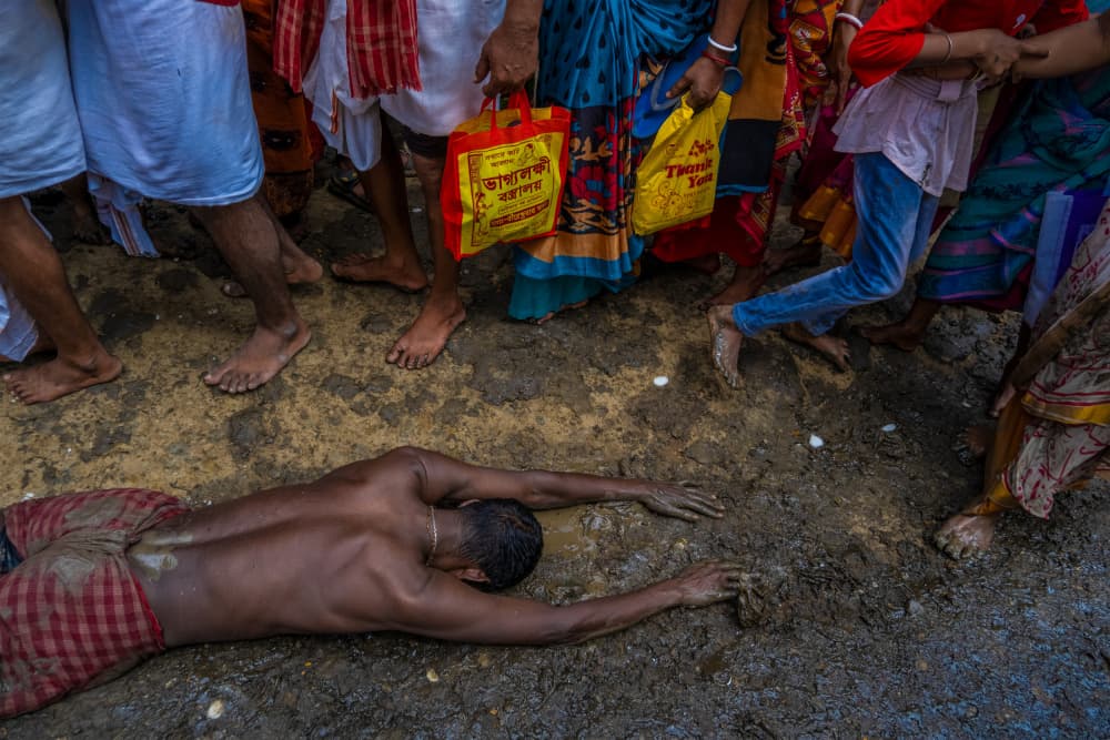 Man Prostrating in Mud by Kuntal Biswas — canvas wall art