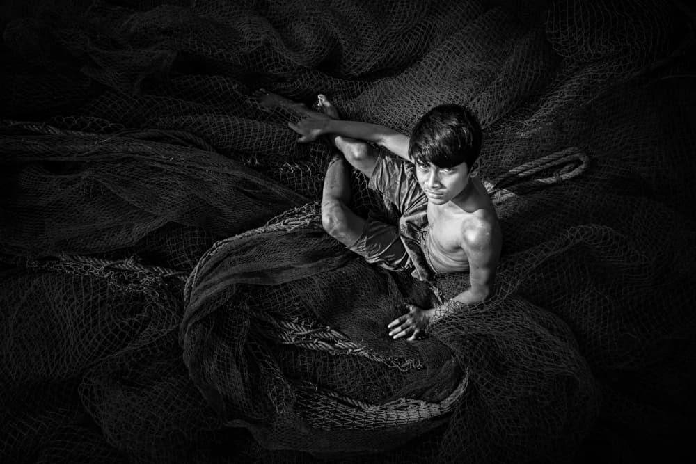 Boy Among Fishing Nets by Kuntal Biswas — canvas wall art