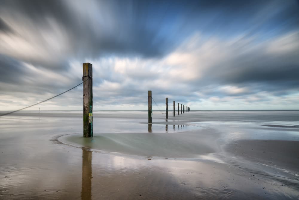 Coastal Poles Reflection by Christophe Staelens — canvas wall art