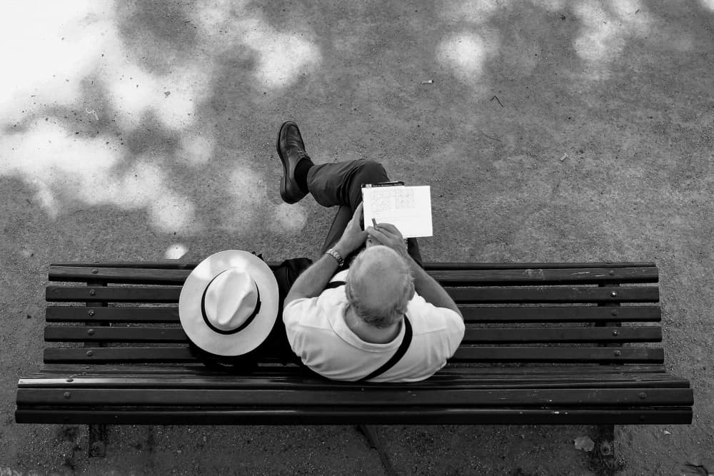 Man Writing On Bench by Miguel Silva — canvas wall art