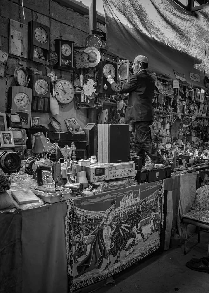Market Man Adjusting Clocks by Bashar Alsofey — canvas wall art
