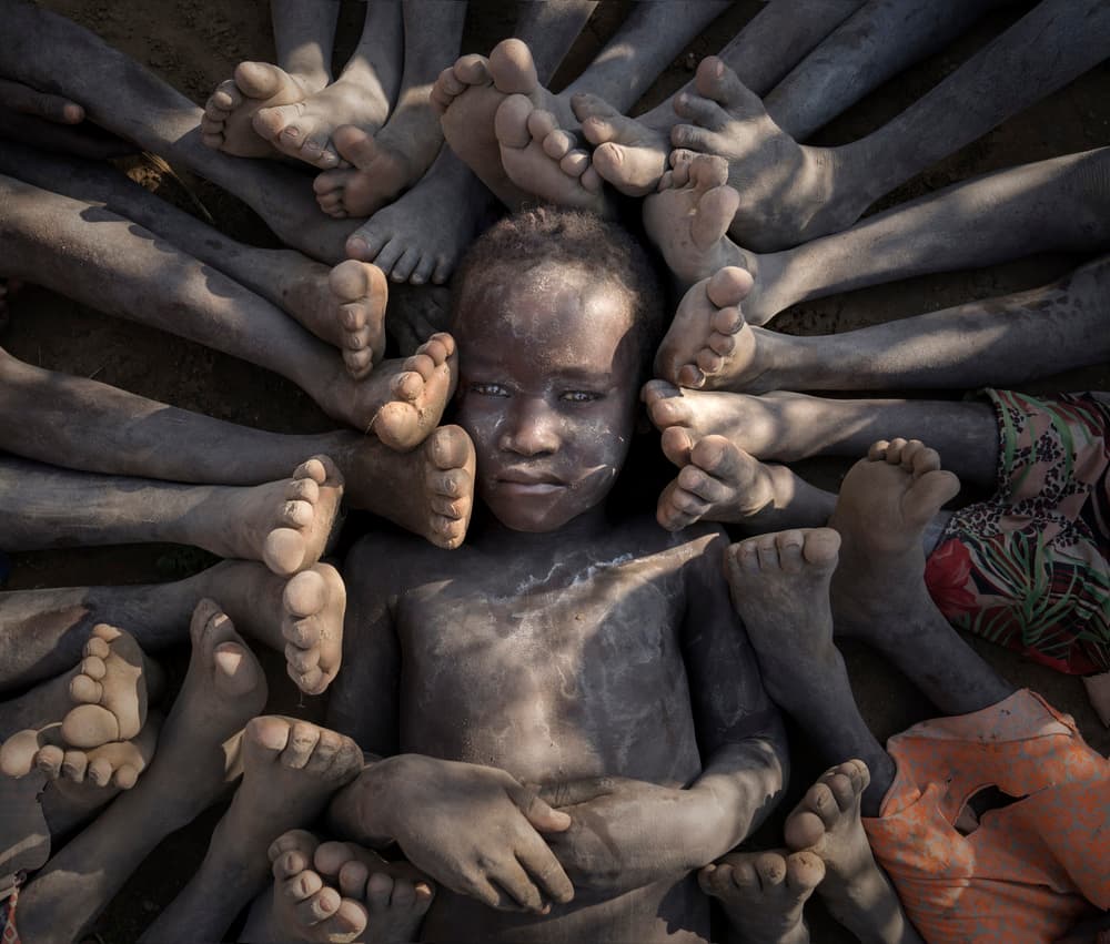 Child Among Feet by Sarawut Intarob — canvas wall art