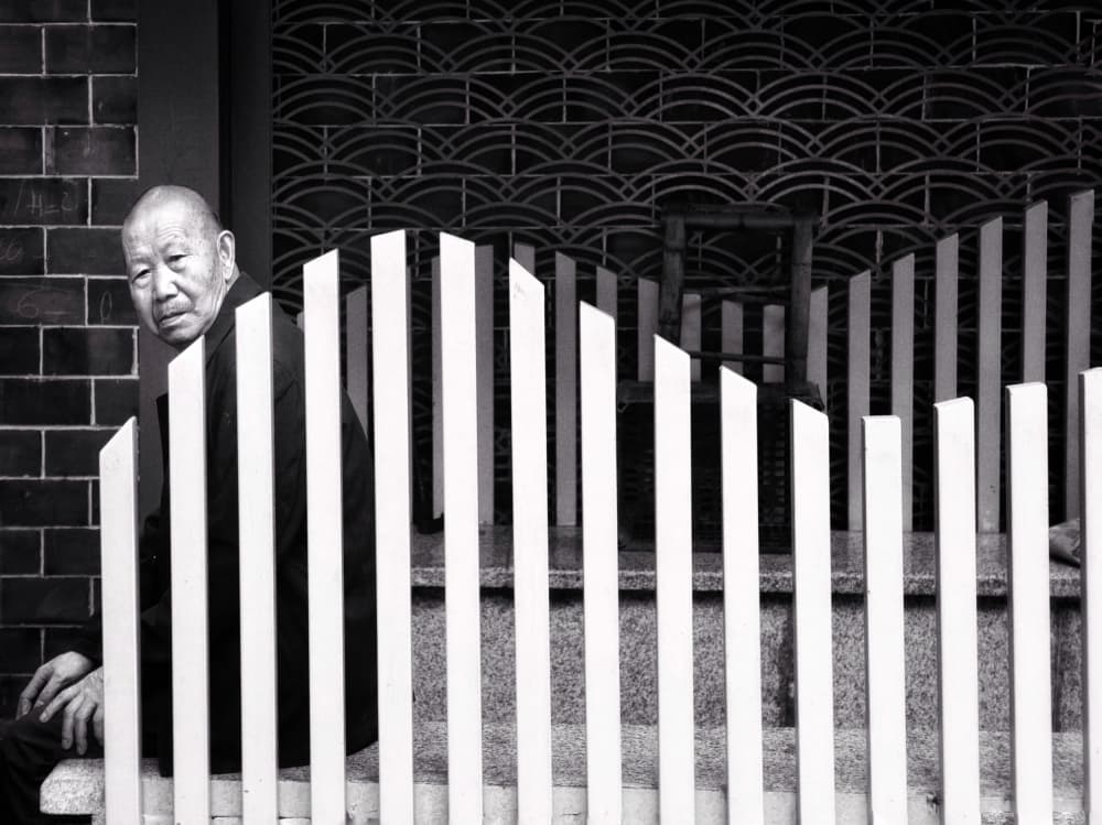 Elderly Man Behind Fence by Jasmine Zhang — canvas wall art