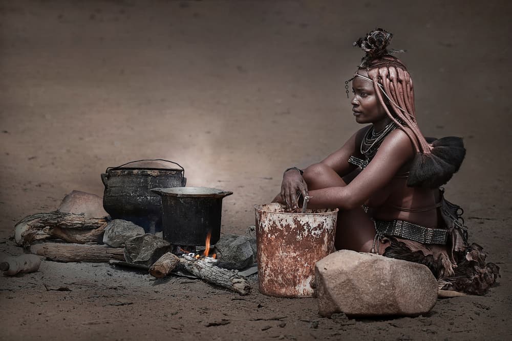 Himba Woman By Fire by Irene Perovich — canvas wall art