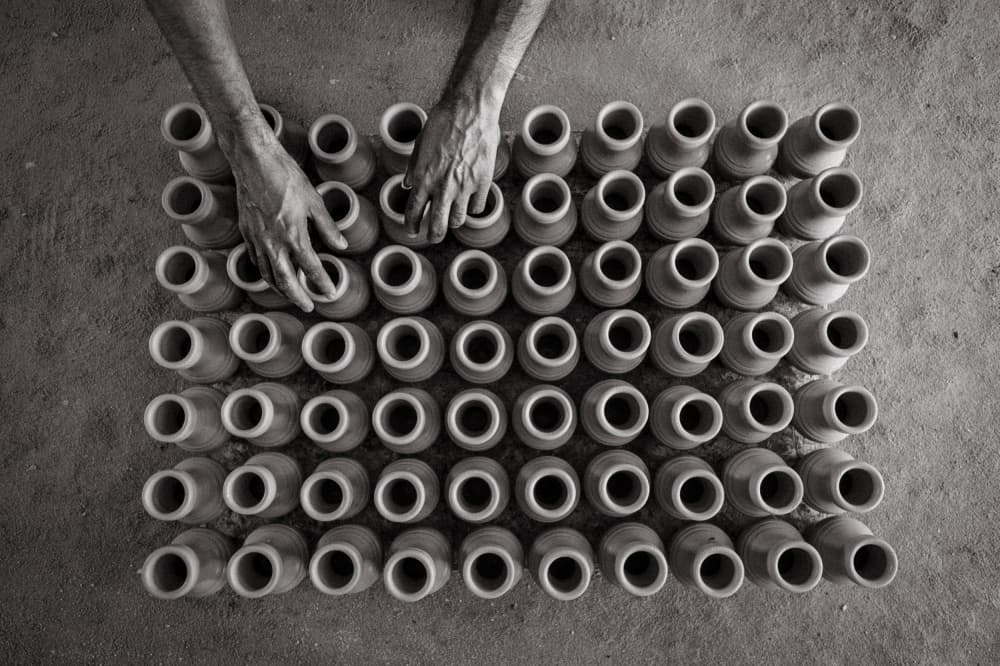 Hands Arranging Clay Pots by Mohammed Al Sulaili — canvas wall art