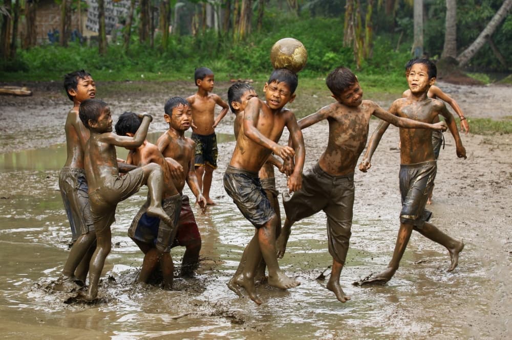 Kids Mud Soccer by Angela Muliani Hartojo — canvas wall art