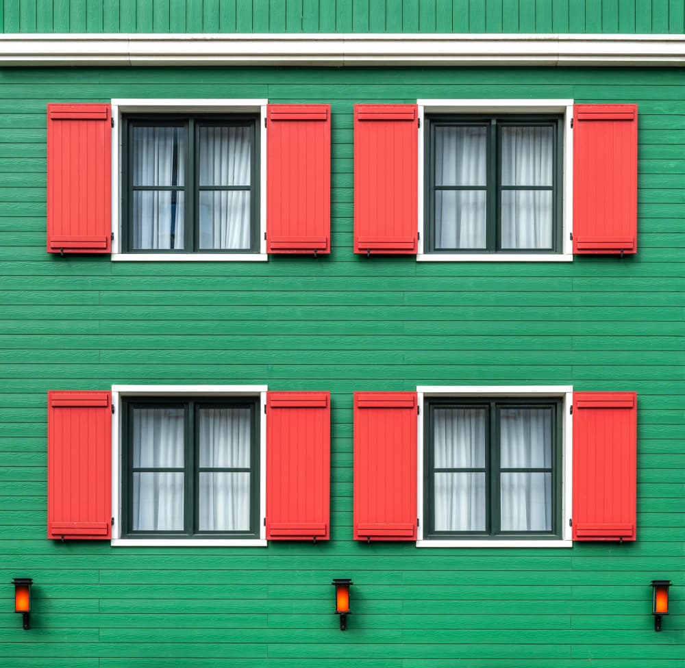 Green Building Red Shutters by Roland M Schwerdtfeger — canvas wall art