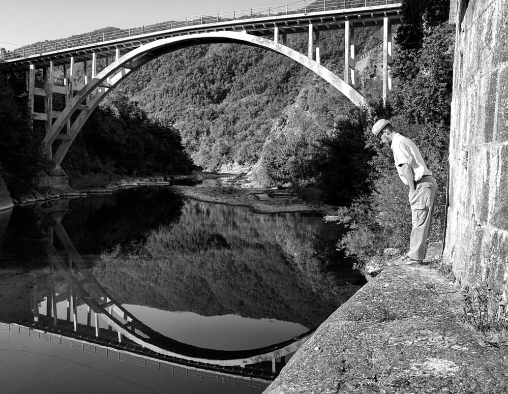 Man By Reflected Bridge by Carlo Ferrara — canvas wall art