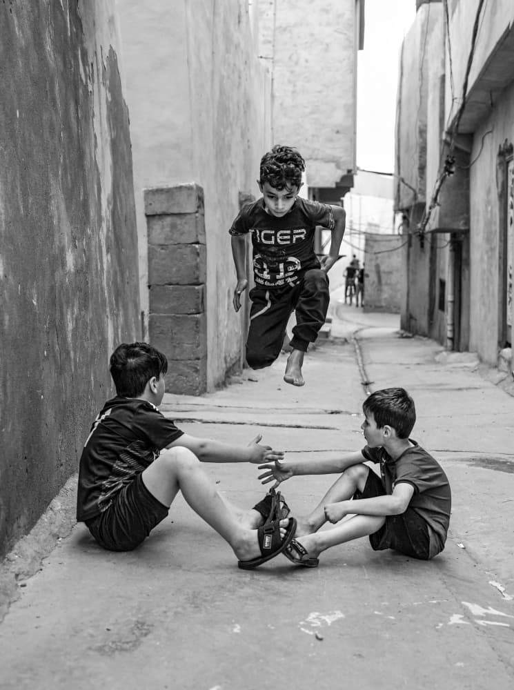 Jumping Boys Alley Play by Bashar Alsofey — canvas wall art