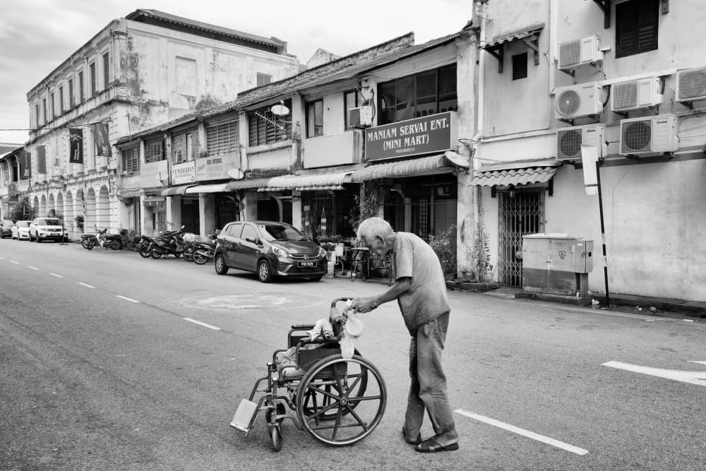 Old Man Pushing Wheelchair by Kieron Long — canvas wall art