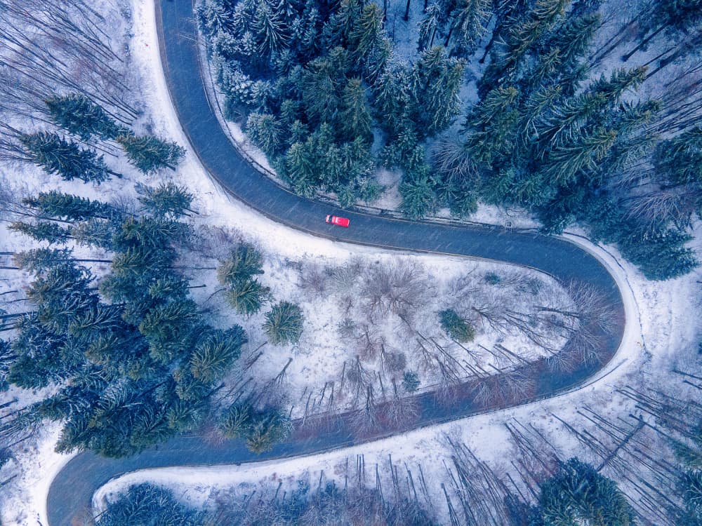 Red Car Winding Winter Road by Dan Mirica — canvas wall art