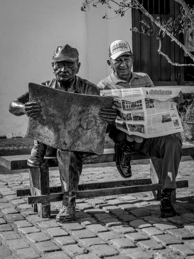 Statue and Man Reading by Eyal Alcalay — canvas wall art