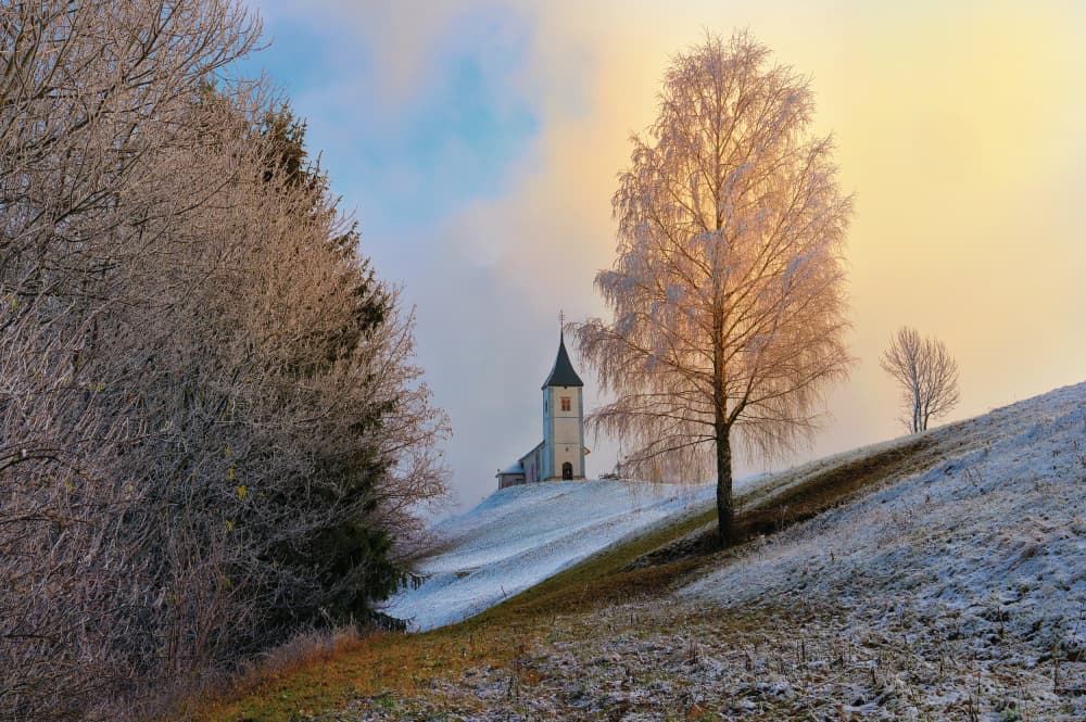 Snowy Hillside Church by Drago Vogrinec — canvas wall art