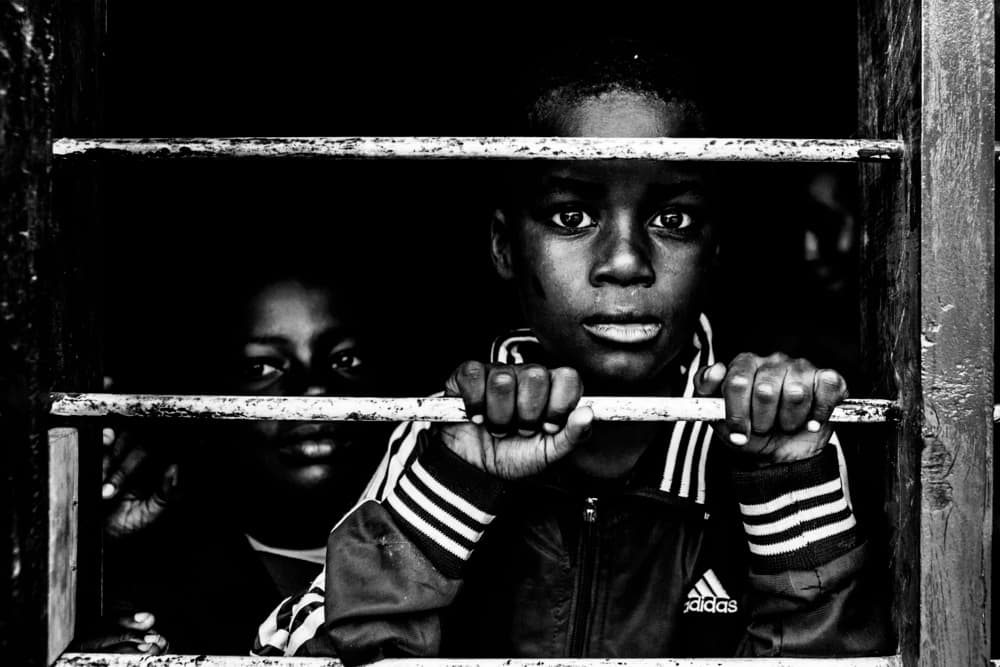 Watchful Boy Behind Bars by Vedran Vidak — canvas wall art