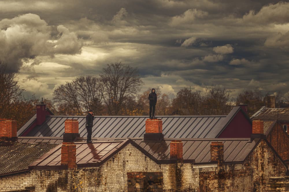Rooftop Figures Under Stormy Sky by Normunds Kaprano — canvas wall art