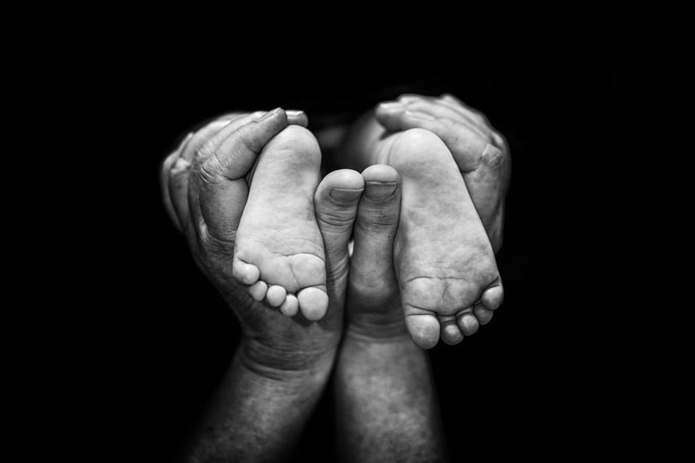 Gentle Hands Holding Baby Feet by Andi Halil — canvas wall art
