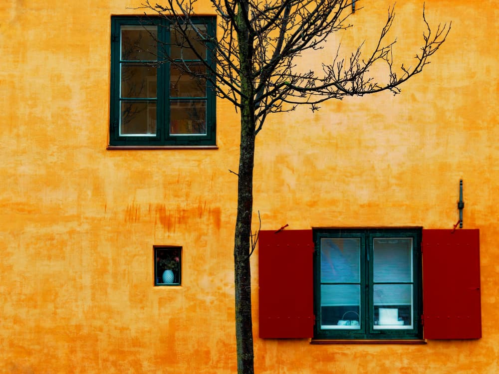 Yellow Wall Red Shutters by Marius Surleac — canvas wall art