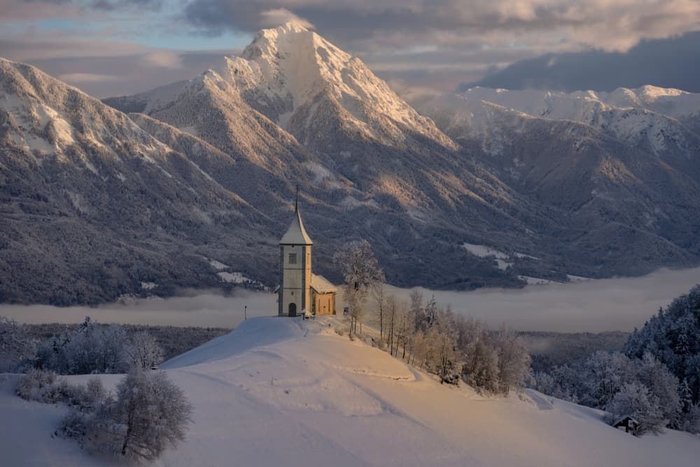 Snowy Alpine Church by Jure Kravanja — canvas wall art