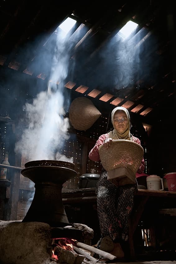 Woman Cooking Sunlit Kitchen by Raymond Sitanggang — canvas wall art