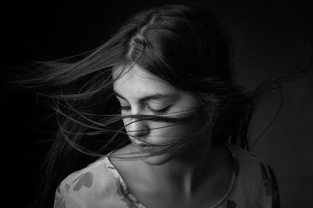 Pensive Girl Blowing Hair by Mehdi Mokhtari — canvas wall art