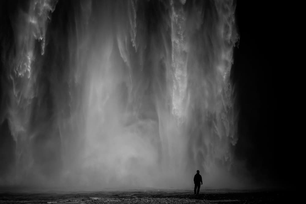Man Beneath Majestic Falls by Jure Kravanja — canvas wall art