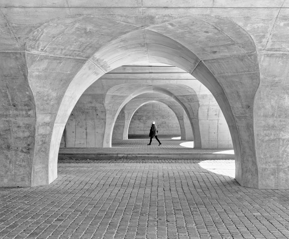 Solitary Walk Through Arches by Andreas Timar — canvas wall art