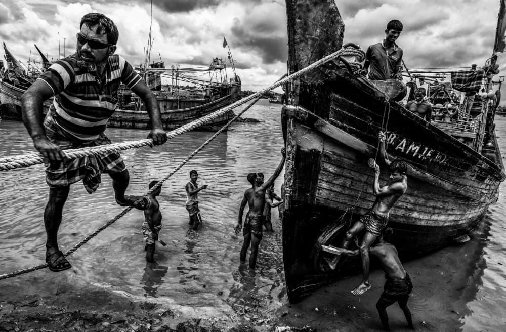 River Men and Boats by Joxe Inazio Kuesta Garmendia — canvas wall art