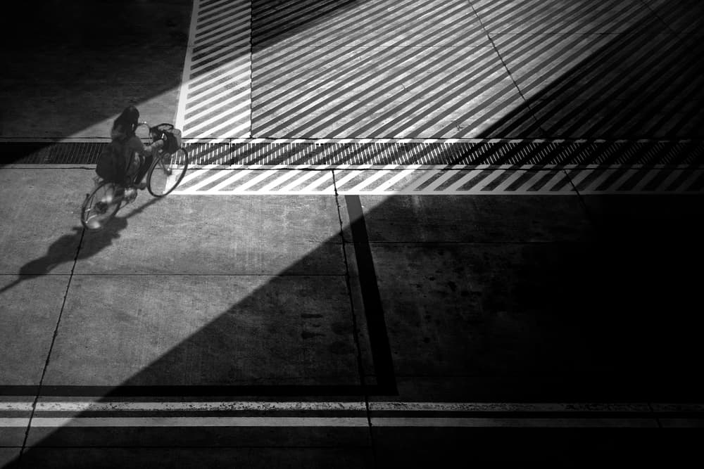 Cyclist in Strong Shadows by Ekkachai Khemkum — canvas wall art