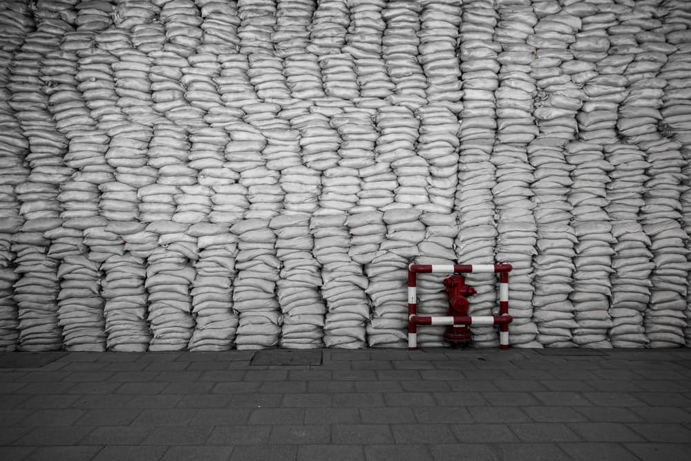 Red Hydrant Sandbag Wall by Muhammad Almasri — canvas wall art