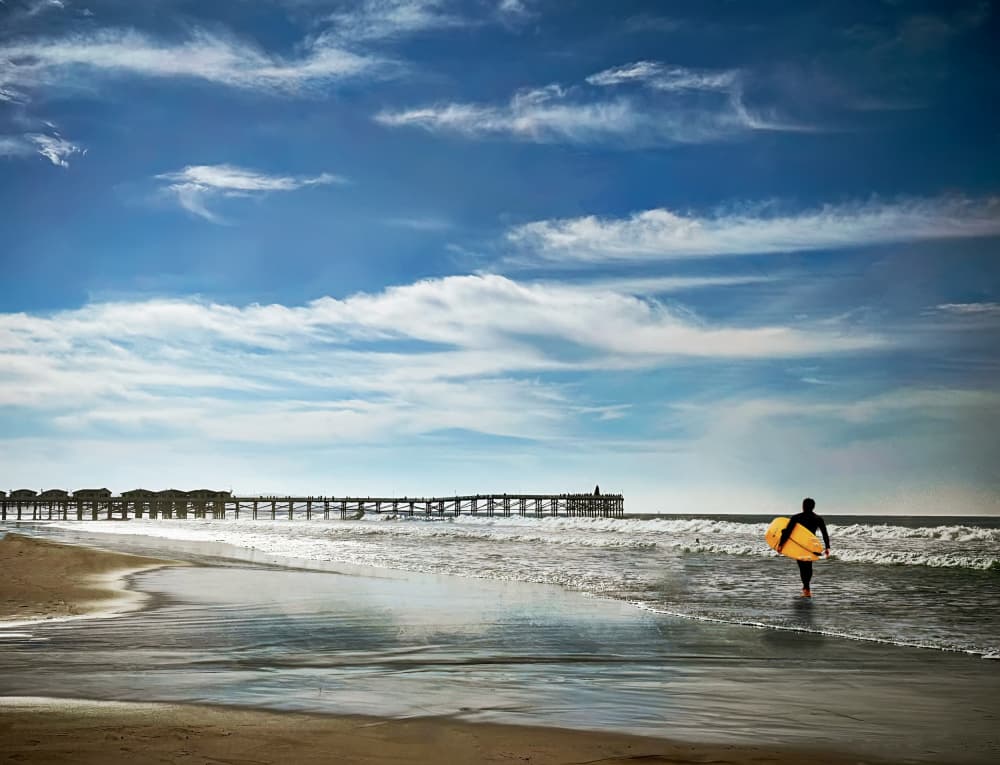 Surfer Walks Ocean by Barbara Fletcher — canvas wall art