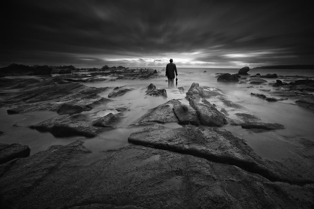 Lone Man Rocky Coast by Hari Sulistiawan — canvas wall art