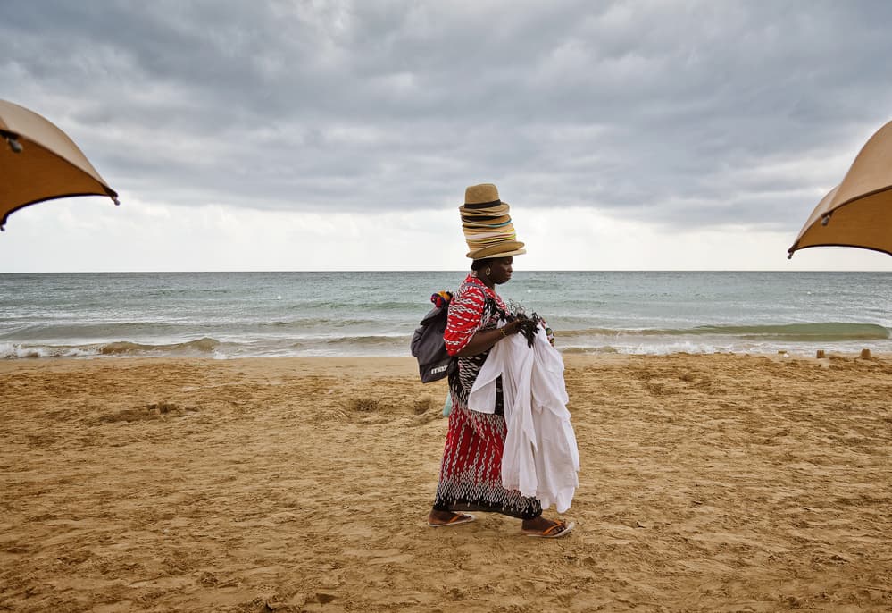 Beach Vendor with Hats by Lorenzo Grifantini — canvas wall art
