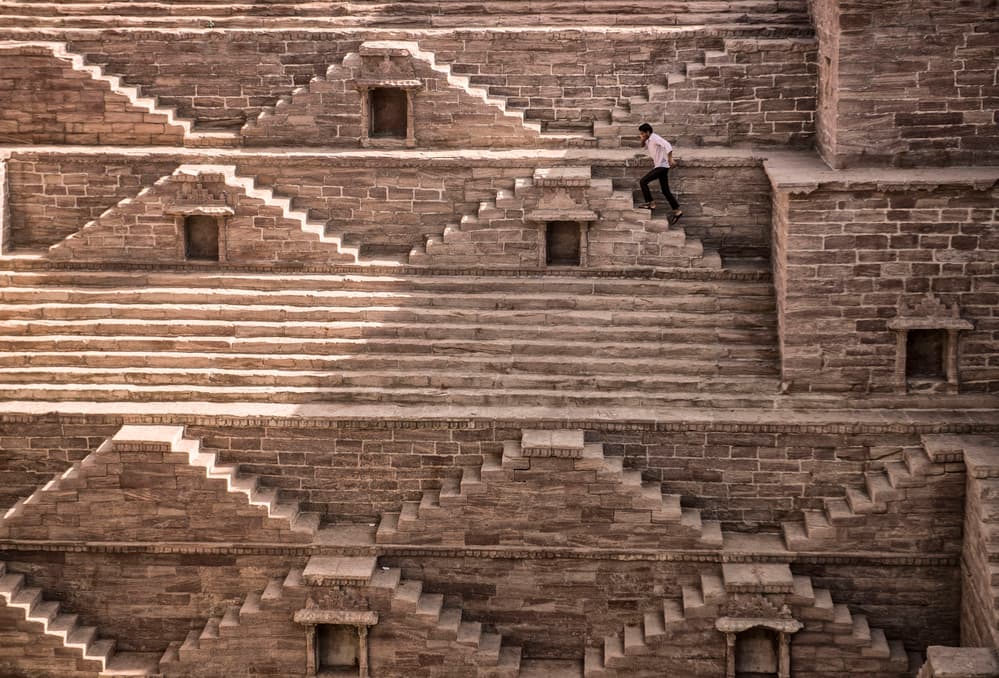 Man Climbing Indian Stepwell by Andrei Nicolas - The Traveler — canvas wall art