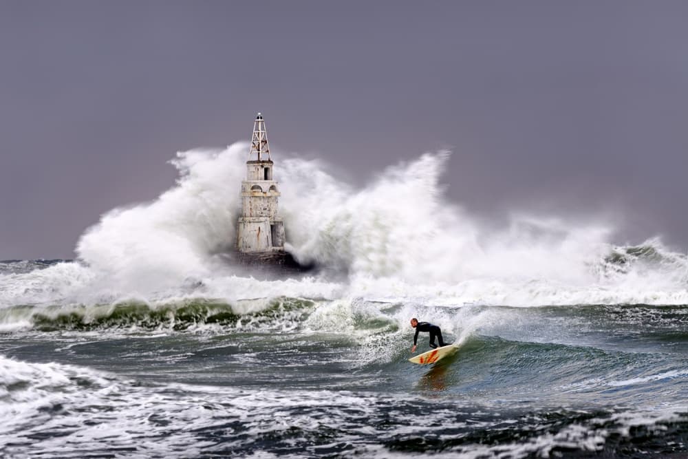 Surfer And Stormy Lighthouse by Milen Dobrev — canvas wall art