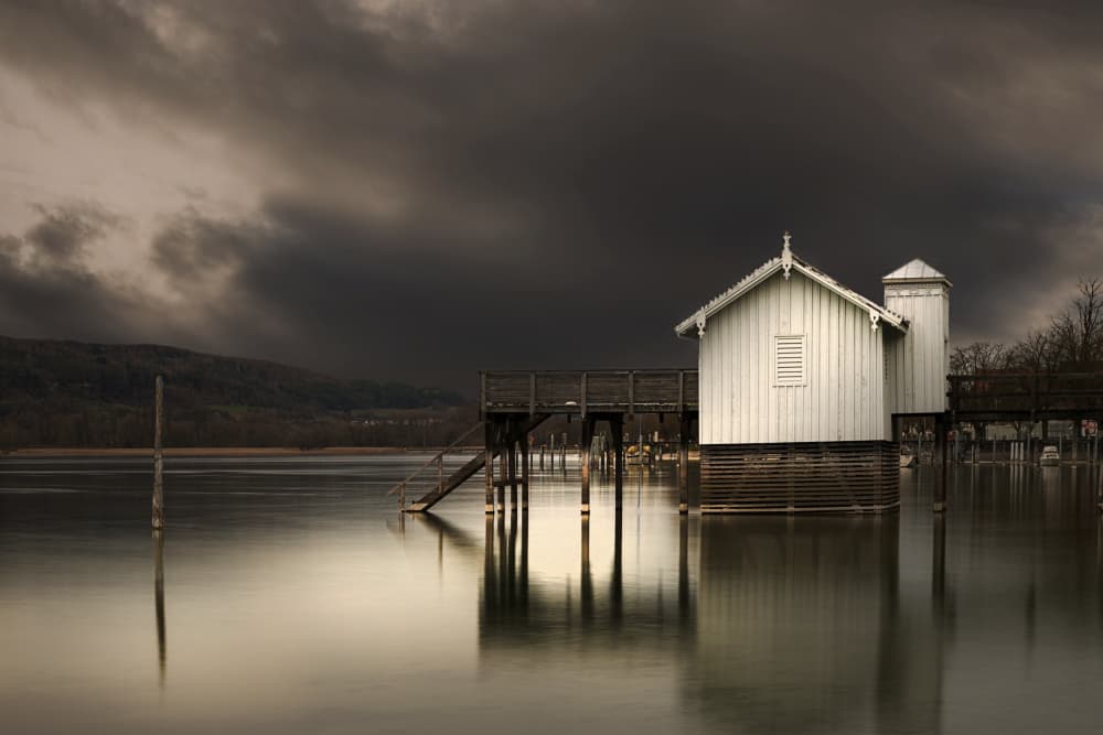Boathouse Under Stormy Sky by Roland Weber — canvas wall art