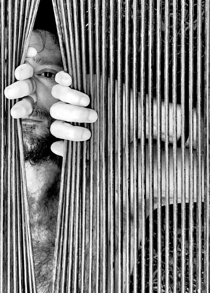Man Peering Through Bars by Davide Barzaghi — canvas wall art