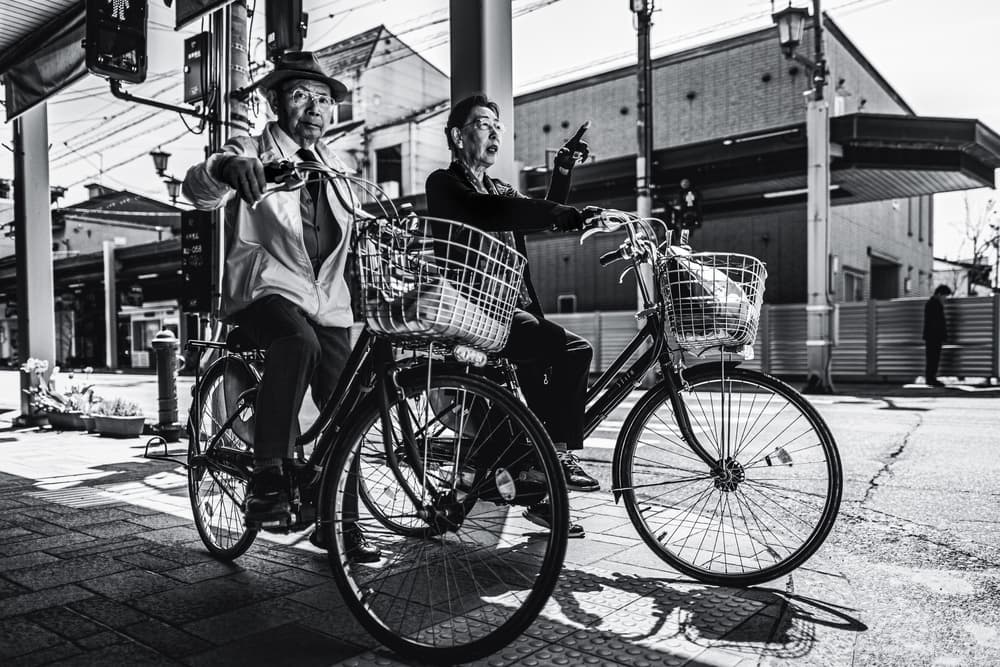 Senior Cyclists Pointing Way by Marco Tagliarino — canvas wall art